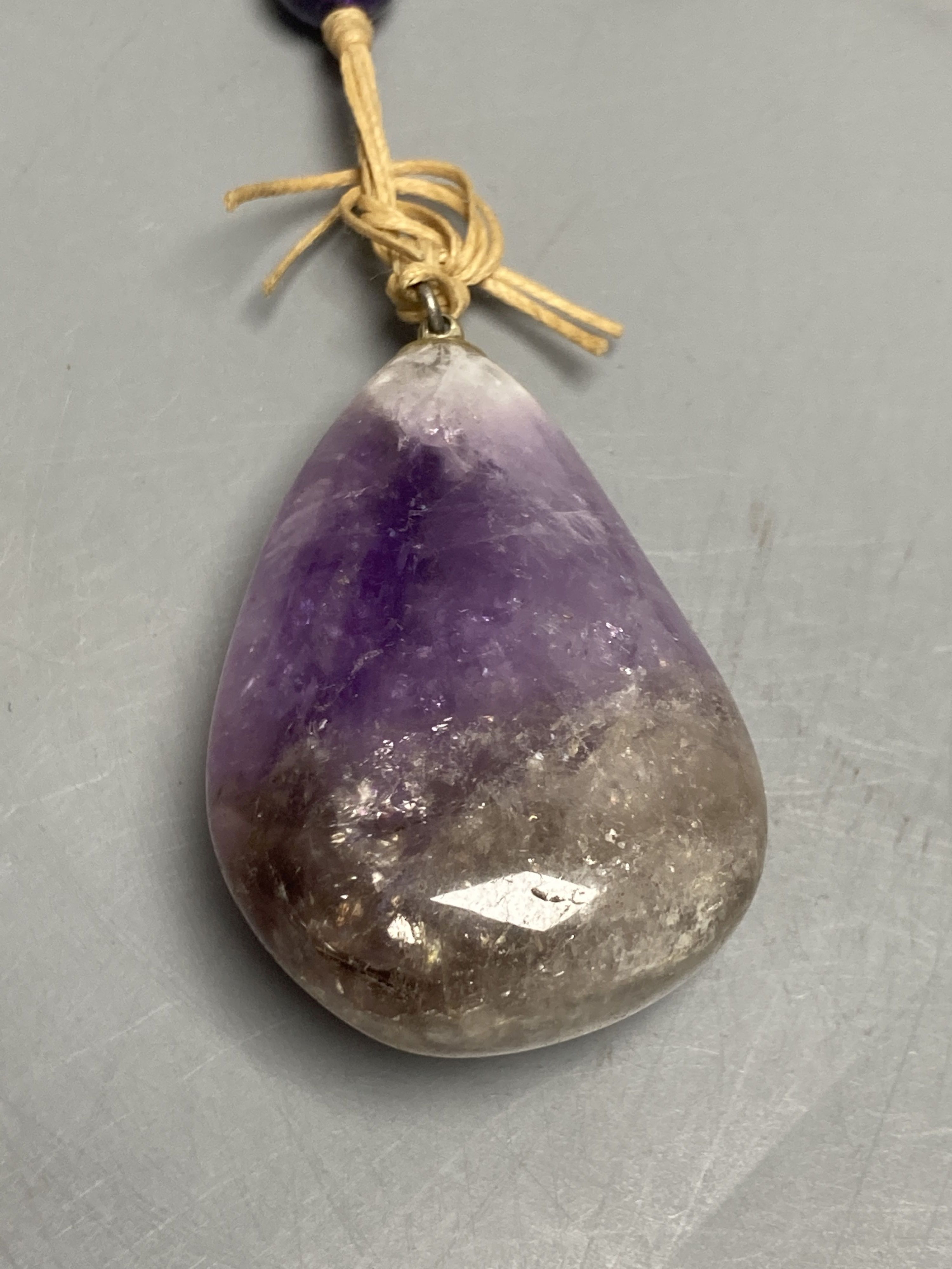 An amethyst bead necklace with amethyst pebble pendant.